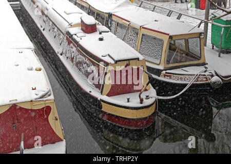 London, Großbritannien, 20. Januar 2013: Lange Wasserbus Boote unter Schnee am Camden Canal in London, UK. Stockfoto