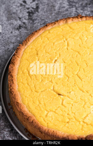 Leckere hausgemachte vegan Lemon cheesecake auf einer Platte, dunkelgrau Stein - Ansicht von oben, Hochformat Kopie Raum Stockfoto