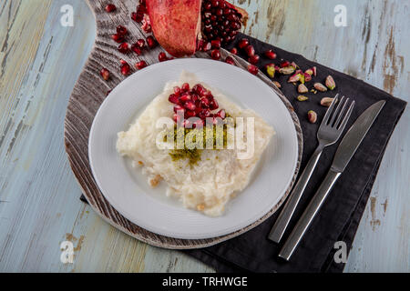 Traditionelle milchig Dessert Gullac, in der Regel machen im Ramadan mit Gullac Blätter, Zucker, Pulver von Pistazien, Milch, Granatapfel, Haselnüsse und Walnuß inside i Stockfoto