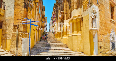 VALLETTA, MALTA - 19. JUNI 2018: Panorama der St John Street mit seinen historischen Gebäuden leben, lange Treppe und Wand Statue des Hl. Antonius in Stockfoto