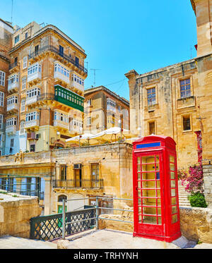 Die städtische Szene in der Altstadt mit Blick auf den mittelalterlichen Wohn häuser und Vintage red Phone Box im Vordergrund, Valletta, Malta. Stockfoto