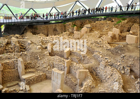 Besucher mit Blick auf die Ausgrabungen der antiken Stein ceremonial site an Gobekli Tepe in Sanliurfa, Türkei Stockfoto