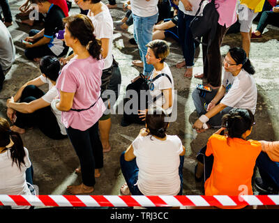 Singapur, 18. Mai 2019 - Devotees sitzen auf dem Boden, während sie darauf warten, die drei Schritte ein Bug Ritual auf der Bright Hill Tempel auf Vesak Tag ausführen Stockfoto