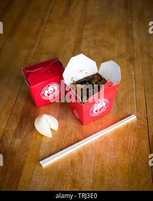 Takeout Boxen von Kung Pao Huhn von Panda Express Restaurant, ein Fortune cookie und chopstocks. Stockfoto