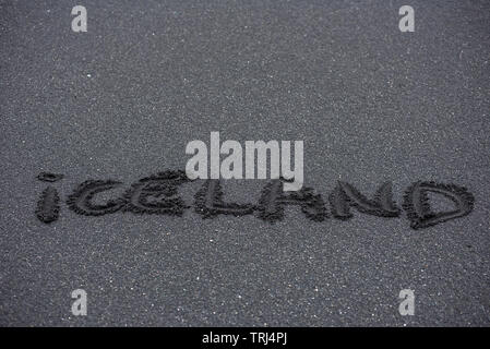 Island Wort handschriftlich auf den schwarzen Strand sand Stockfoto