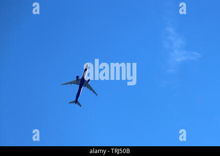 Flugzeug in den klaren, blauen Himmel. Kommerzielle Flugzeug in einen Flug Nahaufnahme, Ansicht von unten Stockfoto