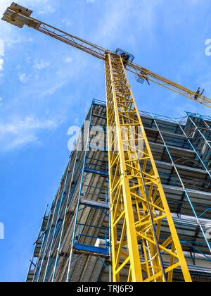 Umfangreiche Gerüst sie Plattformen für die Arbeit an einem neuen Appartementhaus. Baustelle. Gehäuse Kranbetrieb. Hohes Buildin Stockfoto