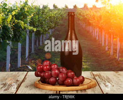 Flasche Rotwein und Weinglas auf Wodden Lauf Stockfoto