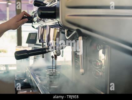 Kaffeemaschine große Maschine Spray mit Barista drehen, Gießen am Cup Stockfoto