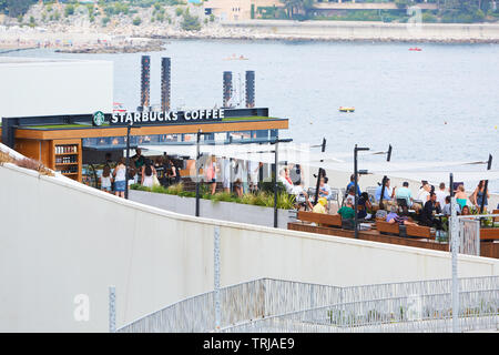 MONTE CARLO, MONACO - 19. AUGUST 2016: Kaffee von Starbucks Cafe Terrasse mit Menschen im Sommer in Monte Carlo, Monaco. Stockfoto