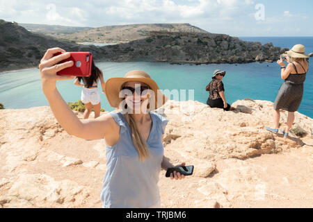 Touristen in der Warteschlange für Foto, Golden Bay, Malta Stockfoto