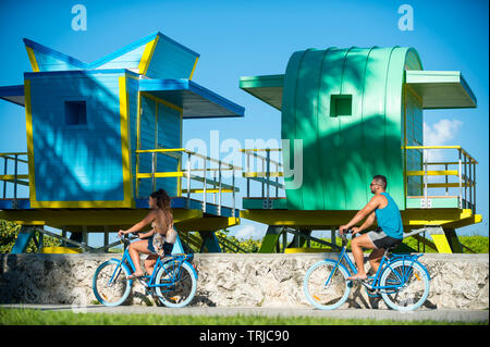 MIAMI - Juli 2017: ein Paar auf Fahrrädern Pass entlang der Strandpromenade vor Leuchtendbunten neu errichtete Rettungstürme. Stockfoto