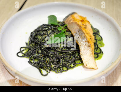 Schwarze Spaghetti Kräutersoße mit gegrillter Lachs auf weiße Platte Stockfoto