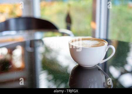 Kaffee Tasse Reflexion auf Glas Tisch im Cafe Stockfoto