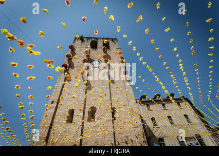 St Cyprien Kirche Glockenturm aus dem 12. Jahrhundert mit festlichen Bunting an einem heißen Sommertag. St Cyprien, Dordogne, Frankreich Stockfoto