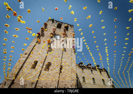 St Cyprien Kirche Glockenturm aus dem 12. Jahrhundert mit festlichen Bunting an einem heißen Sommertag. St Cyprien, Dordogne, Frankreich Stockfoto