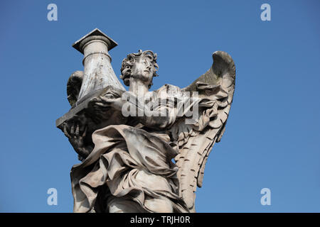 Die Marmorstatue der Engel mit den Nägeln auf der Ponte Sant'Angelo. Die barocke Statue kann gegen den grünen Bäumen am Ufer gesehen werden. Stockfoto