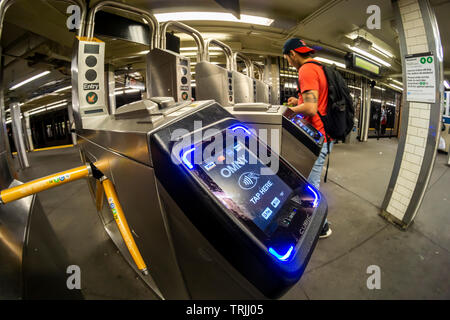 Pendler mit MetroCards vorbei OMNY Leser über Drehkreuze im Osten 23 Street Station in die U-Bahn in New York auf Roll-out Tag, Freitag, 31. Mai 2019. Nach der Implementierung der Zahlungsvorgang, betitelt OMNY, ersetzen die MetroCard aktivieren Tippen und Bezahlen via Smartphones oder aktiviert, Debit- und Kreditkarten. In der Zwischenzeit, ein Test, mit dem IRT Lexington Avenue Linie zwischen Grand Central und Barclays Center in online. (© Richard B. Levine) Stockfoto