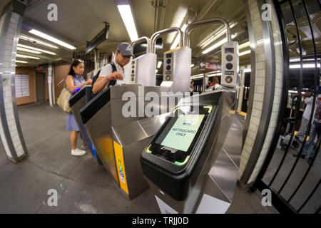 Pendler mit MetroCards vorbei OMNY Leser über Drehkreuze im Osten 23 Street Station in die U-Bahn in New York auf Roll-out Tag, Freitag, 31. Mai 2019. Nach der Implementierung der Zahlungsvorgang, betitelt OMNY, ersetzen die MetroCard aktivieren Tippen und Bezahlen via Smartphones oder aktiviert, Debit- und Kreditkarten. In der Zwischenzeit, ein Test, mit dem IRT Lexington Avenue Linie zwischen Grand Central und Barclays Center in online. (© Richard B. Levine) Stockfoto