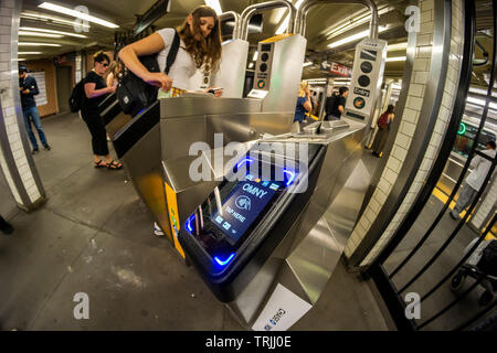 Pendler mit MetroCards vorbei OMNY Leser über Drehkreuze im Osten 23 Street Station in die U-Bahn in New York auf Roll-out Tag, Freitag, 31. Mai 2019. Nach der Implementierung der Zahlungsvorgang, betitelt OMNY, ersetzen die MetroCard aktivieren Tippen und Bezahlen via Smartphones oder aktiviert, Debit- und Kreditkarten. In der Zwischenzeit, ein Test, mit dem IRT Lexington Avenue Linie zwischen Grand Central und Barclays Center in online. (© Richard B. Levine) Stockfoto