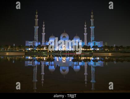 Abudhabi, VAE - Januar 11, 2019: eine Nacht Blick auf die Sheikh Zayed Grand Moschee von einem Wasser Reflexion an Wahat al Karama, Abudhabi, VAE Stockfoto