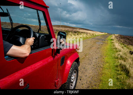 Red Land Rover Defender 110 4WD Auto Navigieren einer Green Lane, North Yorkshire Moors, UK. Stockfoto