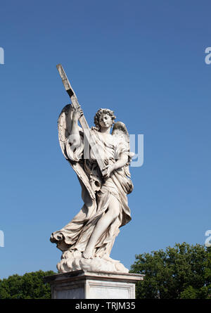 Die Marmorstatue der Engel mit dem Kreuz auf der Ponte Sant'Angelo. Die barocke Statue kann gegen einen tiefen blauen Sommerhimmel gesehen werden. Stockfoto