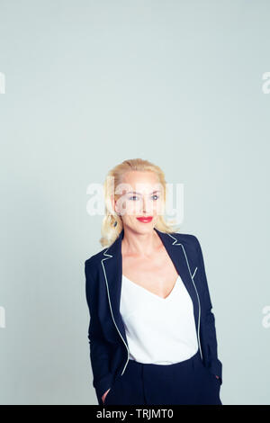 Studio Portrait von schöne blonde Frau in einem schwarzen Kleid gegen Weiße einfachen Hintergrund Stockfoto