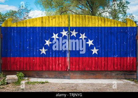 Nahaufnahme der nationalen Flagge Venezuela auf einem hölzernen Tor am Eingang des geschlossenen Gebiet an einem Sommertag. Das Konzept der Lagerung von Waren, Stockfoto