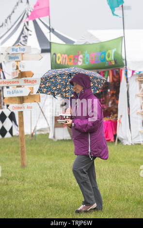 Southwell, Nottinghamshire, Großbritannien. 7. Juni 2019. Heavy Rain die Sprits der Musikliebhaber nicht dämpfen auf der historischen Marktstadt Southwell für das 13 Th. Internationale Wurzeln und akustischer Musik Festival' Tor in Southwell' mit über 50 Künstler, die sich über 4 Tage. Das Festival zieht einige der größten Namen in der Wurzeln und akustischer Musik Szene sowie lokale Talente. Alan Beastall/Alamy leben Nachrichten Stockfoto