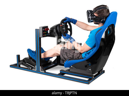 Gamer im blauen T-Shirt mit VR virtual reality Brillen Training am Simulator simracing Aluminium Rigg für video spiel racing. Motorsport auto Schalensitz st Stockfoto