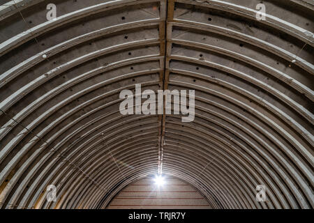 Verlassene leere Lager, alten rustikalen Metall Struktur mit Metalldächer, Interieur der alten Fabrik gebäude Stockfoto