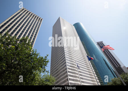 Fliegen amerikanische Flaggen von hohen Wolkenkratzern in Houston, Texas, USA umgeben. Stockfoto