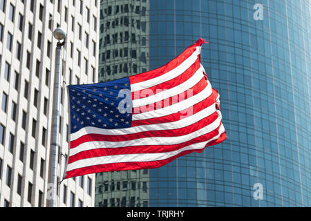 Fliegen amerikanische Flaggen von hohen Wolkenkratzern in Houston, Texas, USA umgeben. Stockfoto