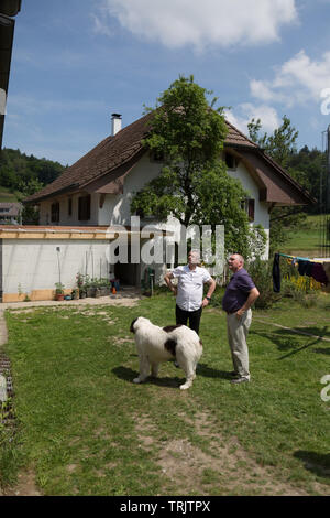 Zwei Männer, die hinter einer alten Schweizer Bauernhaus aus dem 19. Jahrhundert im Aargau, Schweiz. Stockfoto