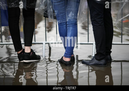 Details mit den Füßen von Jugendlichen im Wasser stehend, auf einer öffentlichen Versammlung (Musikfestival) Stockfoto