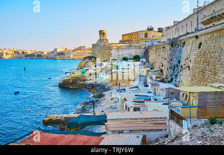 Die zahlreichen Fischerhütten an der hohen Stadtmauer von Valletta, Malta Stockfoto