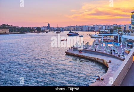 SLIEMA, MALTA - 19. Juni 2018: Die Promenade von Tigne Point Halbinsel ist schön für die abendliche Spaziergänge, mit Blick auf den Hafen, die moderne neighborhoo Stockfoto