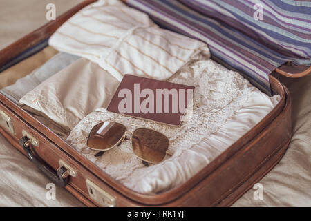 Traveler's Tasche mit Kleidung, Accessoires und Reisepass, Reisen und Urlaub Konzept öffnen Stockfoto