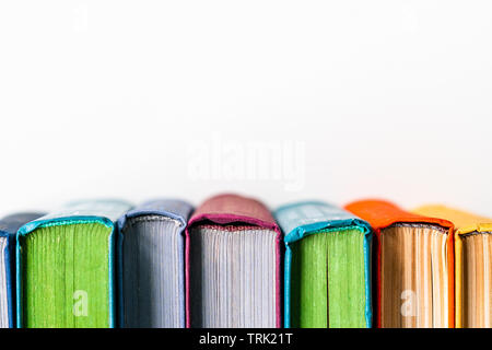 Stapel alte bunte Bücher auf weißem Hintergrund mit Copyspace, Ansicht von oben Stockfoto