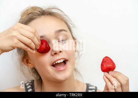 Portrait von yaung Frau essen Erdbeeren. Gesund glücklich lächelnde Frau Erdbeeren essen. Gesunde, Lifestyle Konzept. Stockfoto
