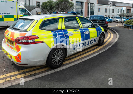 Die Polizei und einen Krankenwagen außerhalb der Unfall- und Notfallambulanz der Uniklinik Wishaw, Schottland geparkt. Parkplatz und Haupteingang. Stockfoto