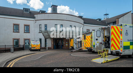 Vier Notarztwagen und ein Polizeiwagen vor dem Eingang zum Unfall- und Notfallambulanz des University Hospital, Wishaw, Schottland geparkt Stockfoto