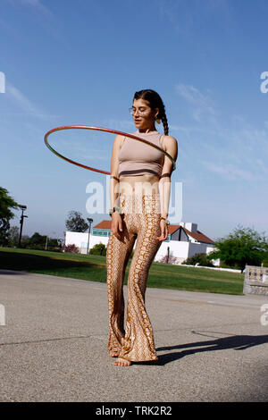 Hula hooper am Nachmittag durchführen für Passanten Stockfoto