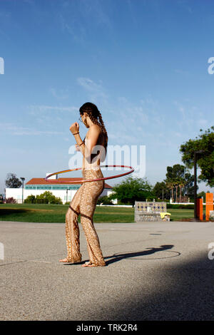 Hula hooper am Nachmittag durchführen für Passanten Stockfoto