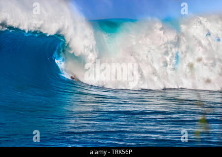 Ein Surfer geht nach unten in die Wellen an Peahi, auch als Backen bekannt, aus Maui's Northshore, Hawaii. Stockfoto