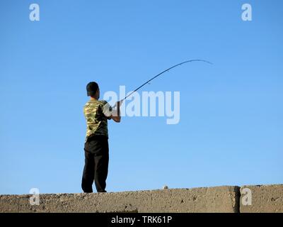 Junger Mann angeln vom Pier in Heraklion, Kreta, Griechenland. Stockfoto