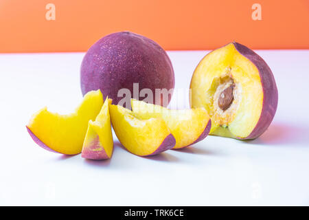 Schöne elegante Komposition aus Reif saftig rot Nektarinen. Orange hinterlegt. Stockfoto