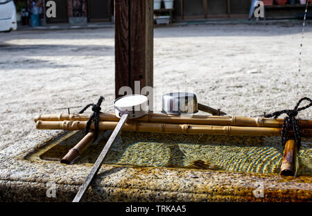 Eine steinerne Wasserbecken und Pfannen bei Wani Ontakeyama Heiligtum in Otsu, Japan. Stockfoto