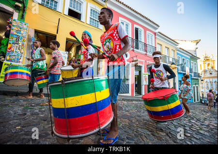 SALVADOR, BRASILIEN - MÄRZ 2018: Eine Gruppe von Trommlern vor bunten kolonialen Architektur von Pelourinho, dem historischen touristischen Bezirk durchführen. Stockfoto